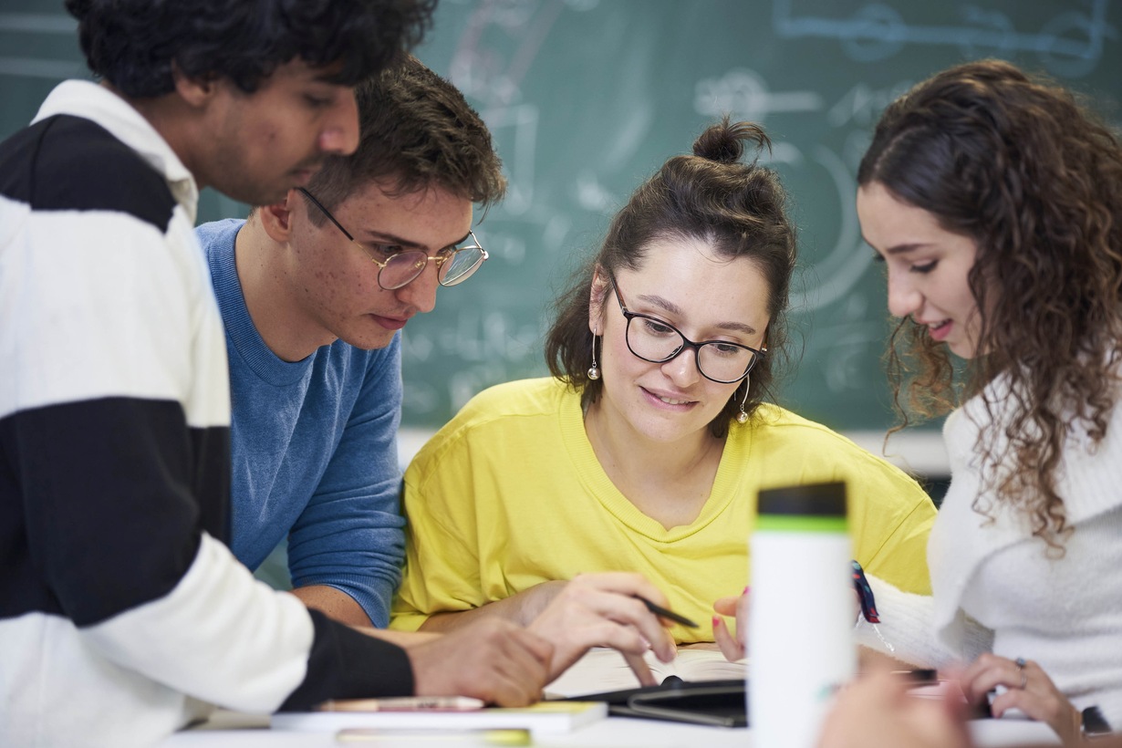 Schmuckfoto: Vier Studierende schauen auf ein Tablet